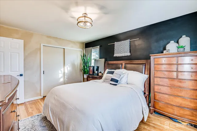 a bedroom with a bed and painting on the wall