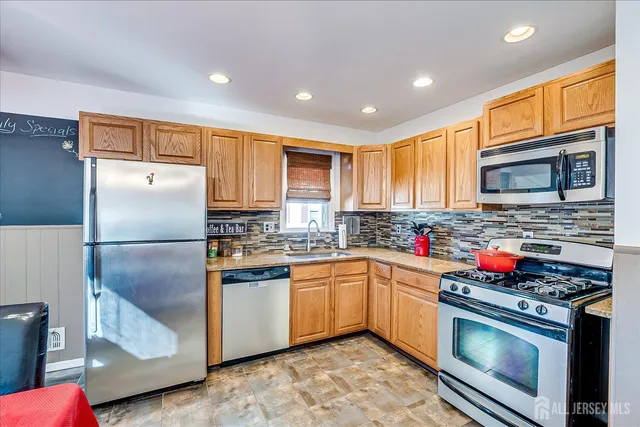 a kitchen with stainless steel appliances granite countertop a refrigerator stove microwave and sink