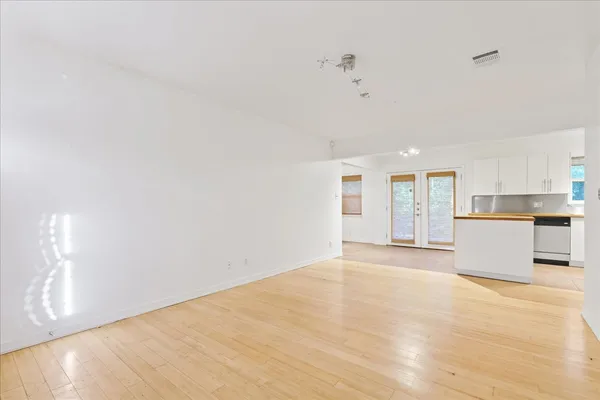 a view of empty room with wooden floor and window