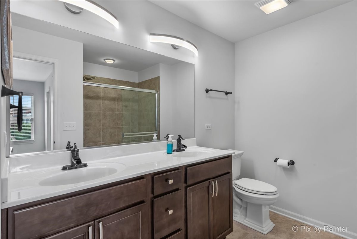 1196 Colfax Avenue Des Plaines, IL 60016 - Photo 13 of 28 a bathroom with a double vanity sink toilet and mirror