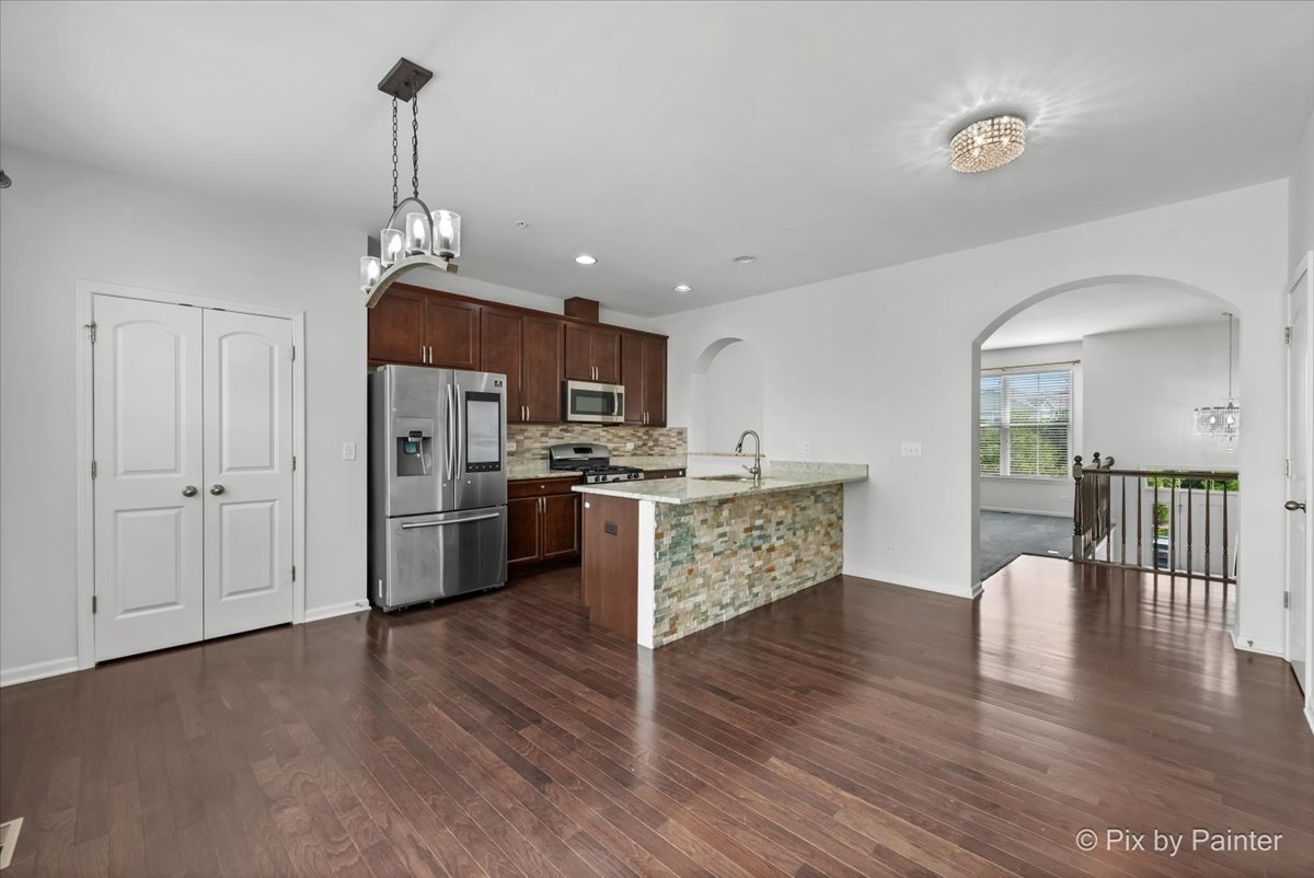 1196 Colfax Avenue Des Plaines, IL 60016 - Photo 5 of 28 a kitchen with stainless steel appliances kitchen island granite countertop a refrigerator a stove a sink dishwasher and white cabinets with wooden floor