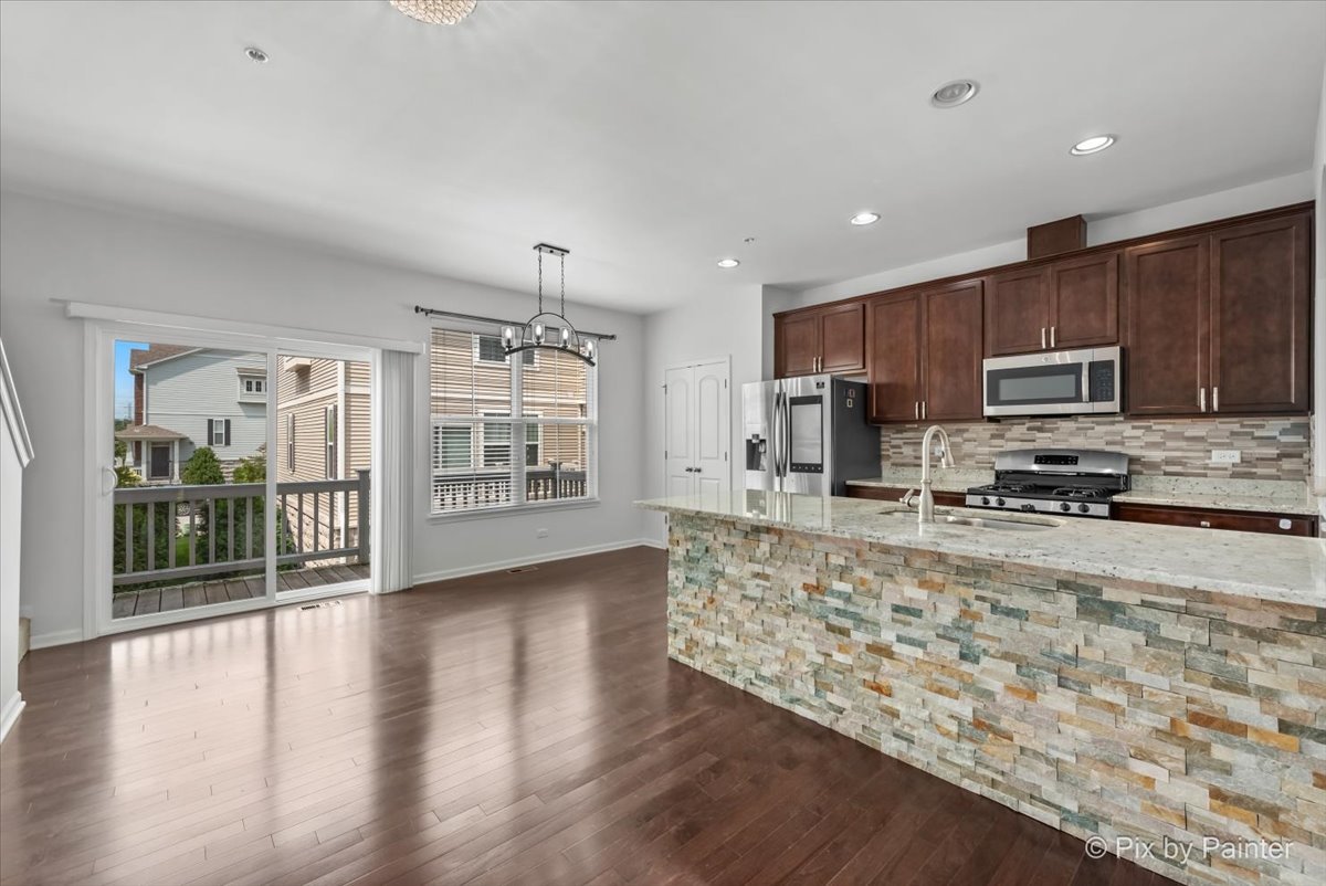 1196 Colfax Avenue Des Plaines, IL 60016 - Photo 8 of 28 a large kitchen with stainless steel appliances granite countertop a large counter top a stove and a wooden floors