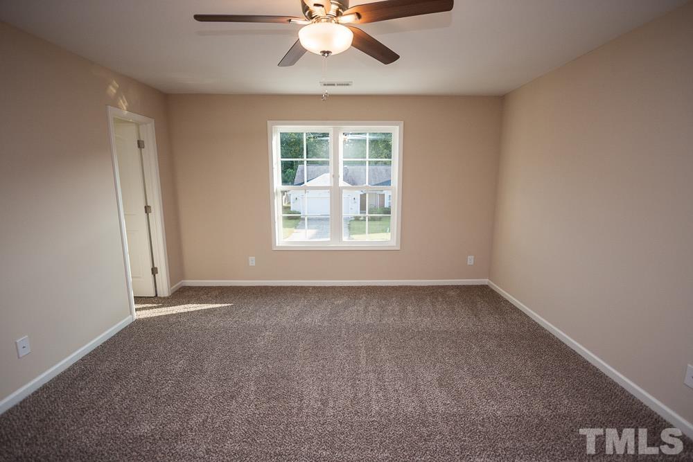 1856 Swepsonville Road Graham, NC 27253 - Photo 13 of 25 an empty room with a window and a ceiling fan