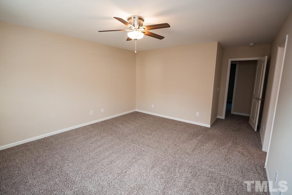 1856 Swepsonville Road Graham, NC 27253 - Photo 15 of 25 an empty room with a chandelier fan and windows