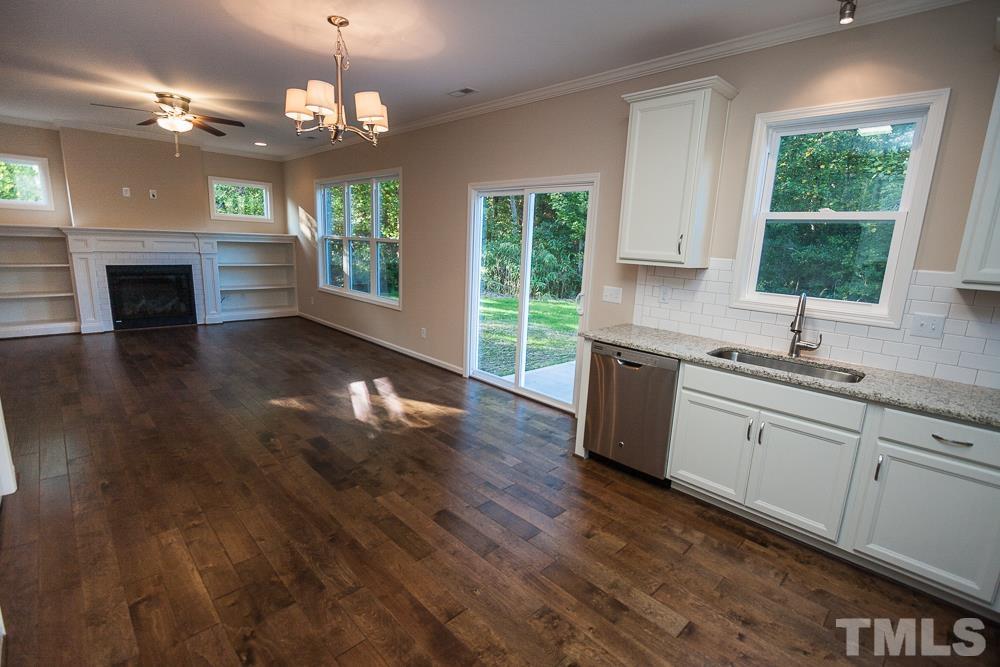 1856 Swepsonville Road Graham, NC 27253 - Photo 7 of 25 a kitchen with granite countertop a stove a sink a refrigerator dining table and chairs