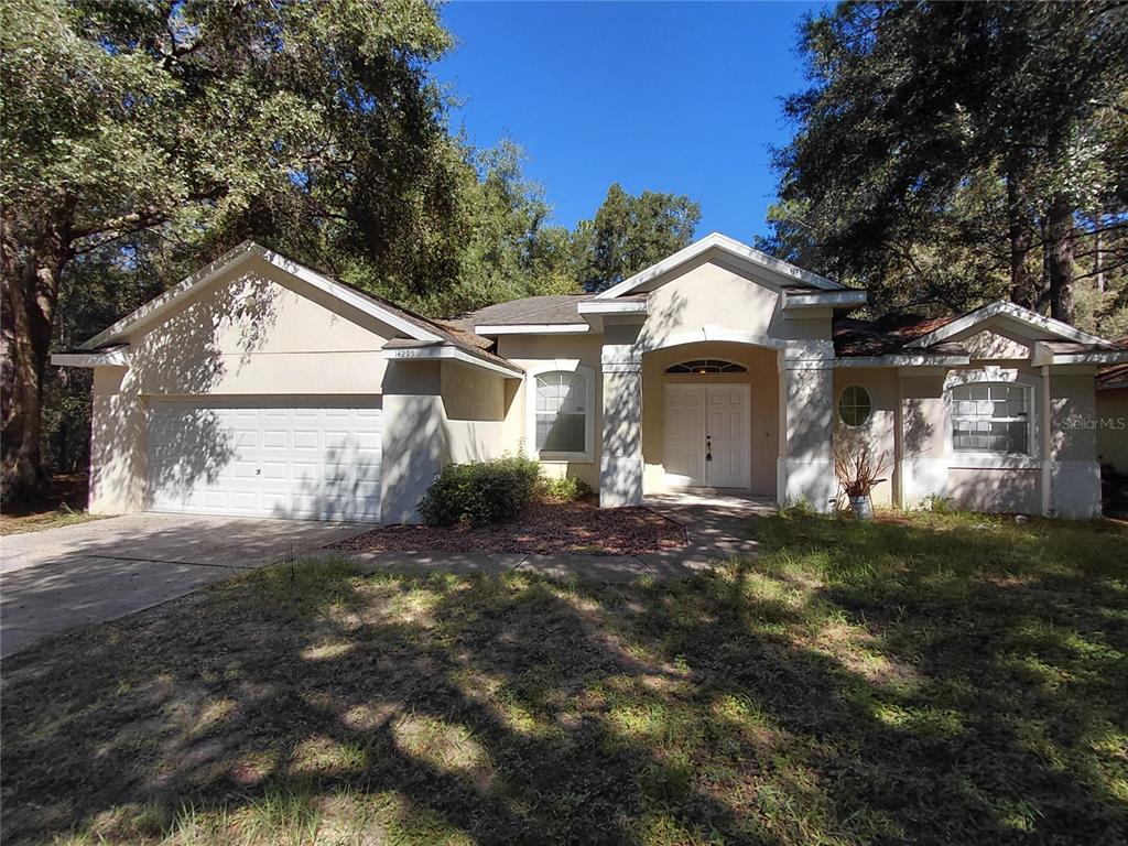 14295 Southwest 17th Place Ocala, FL 34481 - Photo 1 of 34 a front view of a house with a yard and garage