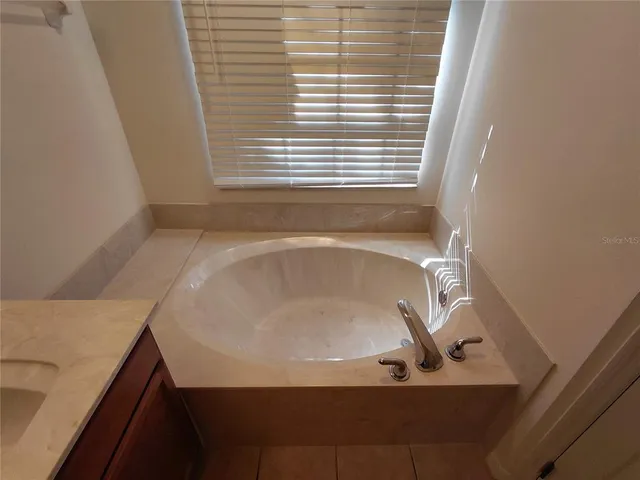a bath tub sitting in a bathroom next to a window