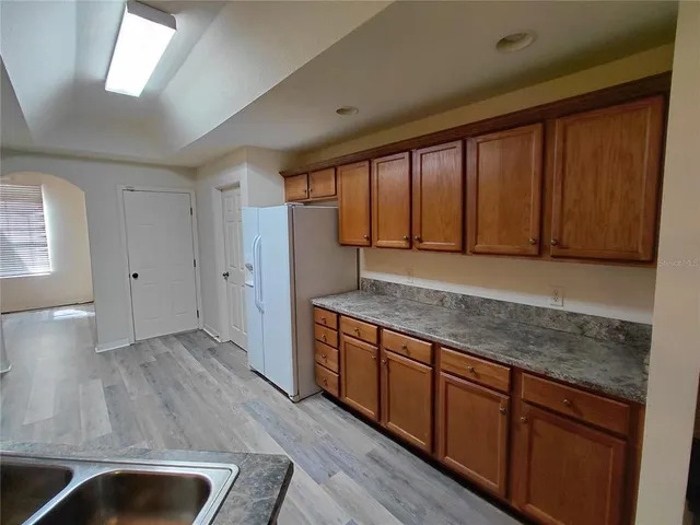 a view of kitchen with stainless steel appliances granite countertop wooden cabinets a sink and a large window