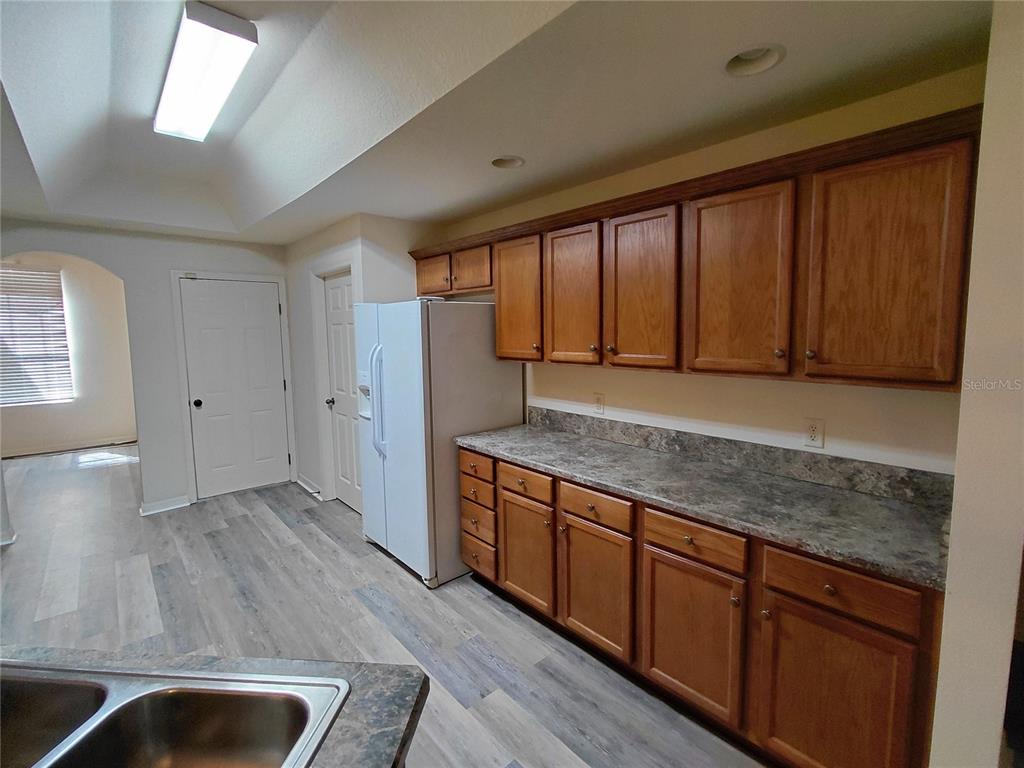 14295 Southwest 17th Place Ocala, FL 34481 - Photo 19 of 34 a view of kitchen with stainless steel appliances granite countertop wooden cabinets a sink and a large window