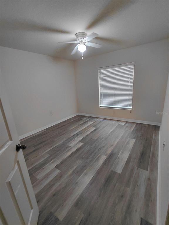 14295 Southwest 17th Place Ocala, FL 34481 - Photo 29 of 34 a view of an empty room with wooden floor and a fan
