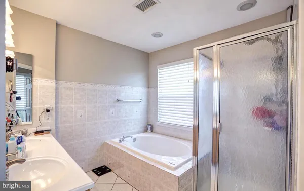 a bathroom with a sink mirror and a shower