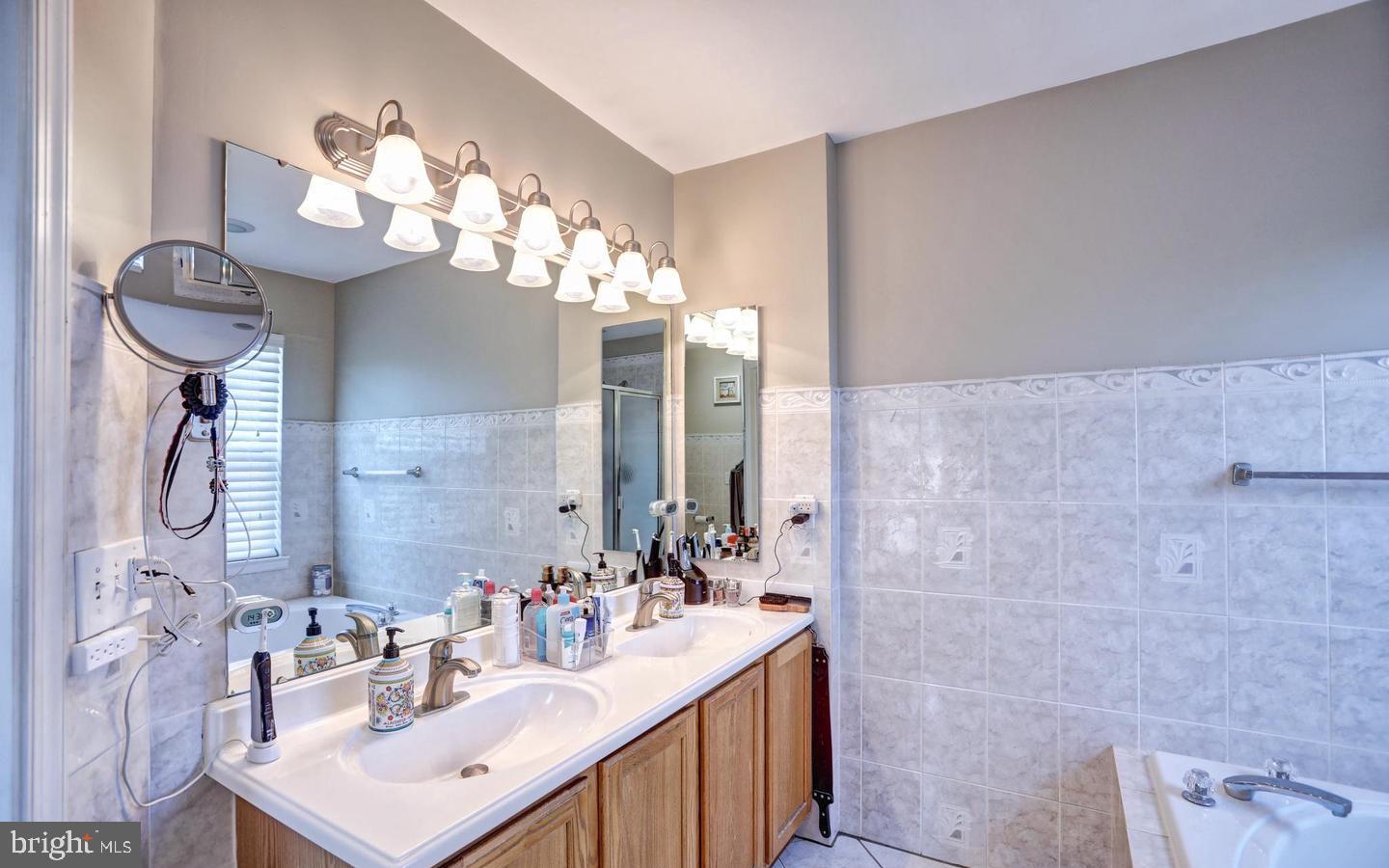 102 Cagney Terrace Southeast Leesburg, VA 20175 - Photo 18 of 26 a bathroom with a sink mirror and a shower