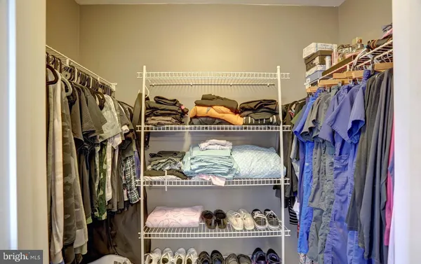 a view of walk in closet with clothes