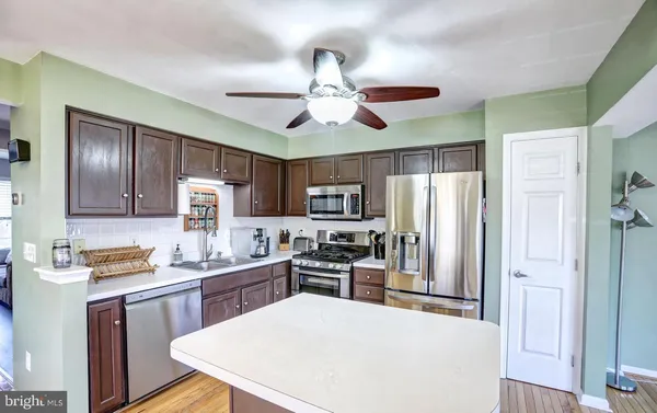 a kitchen with cabinets a refrigerator and microwave