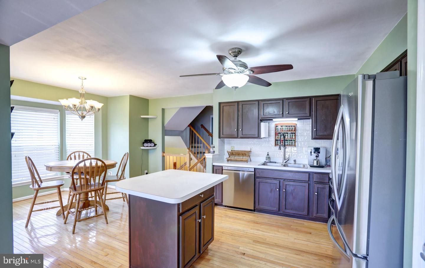 102 Cagney Terrace Southeast Leesburg, VA 20175 - Photo 9 of 26 a kitchen with stainless steel appliances a table chairs and a refrigerator