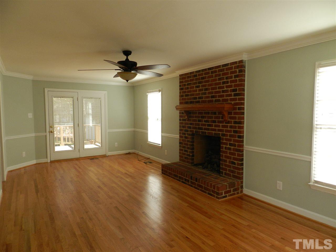 103 Rother Lane Durham, NC 27707 - Photo 5 of 24 an empty room with wooden floor fireplace and windows
