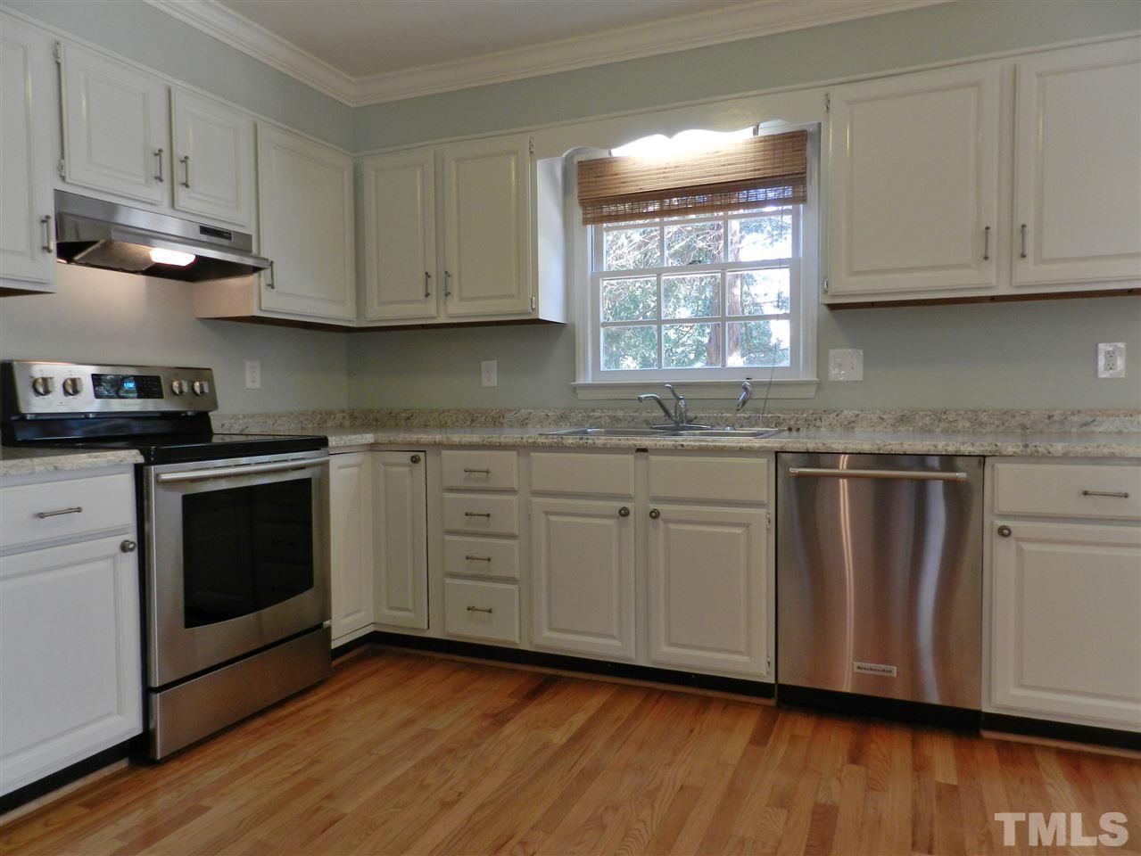 103 Rother Lane Durham, NC 27707 - Photo 10 of 24 a kitchen with granite countertop stainless steel appliances a stove a sink and white cabinets