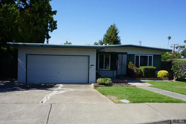 a front view of a house with a garden and yard