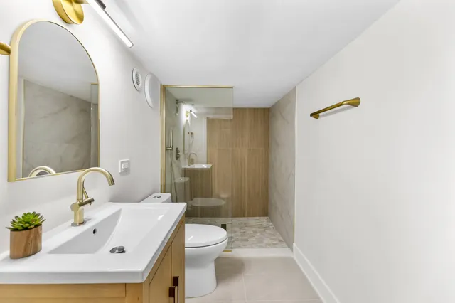 a bathroom with a sink a toilet and shower