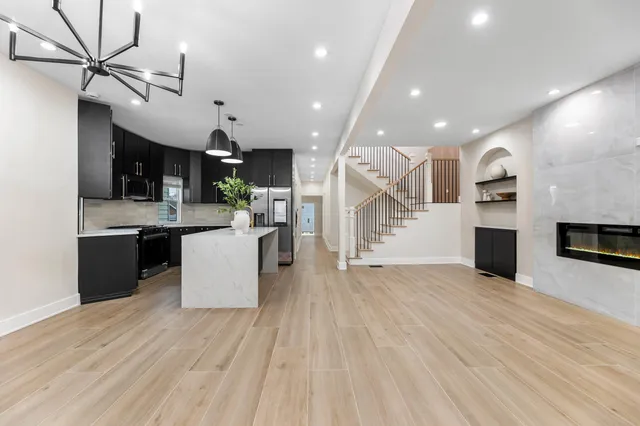 a view of a kitchen with cabinets stainless steel appliances and a chandelier