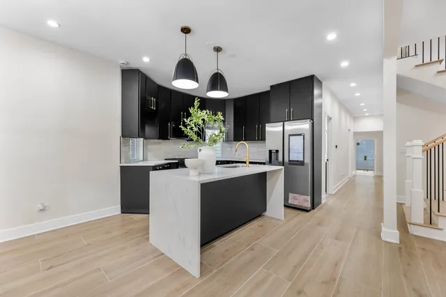 a kitchen with stainless steel appliances kitchen island a refrigerator and a stove top oven