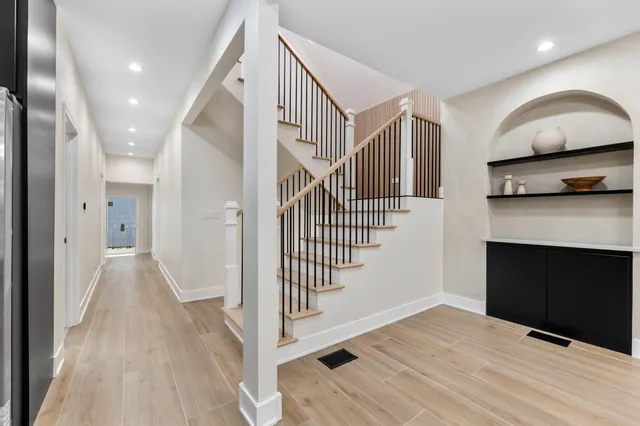 a view of a hallway with wooden floor and staircase
