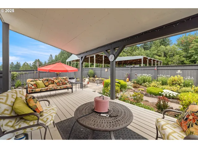 a view of a patio with furniture and a garden
