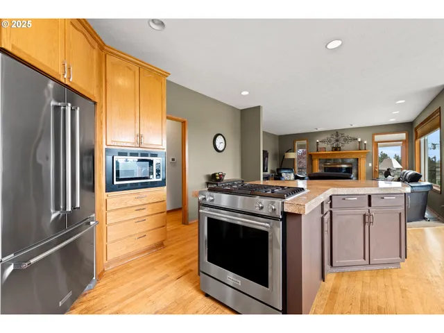 a kitchen with stainless steel appliances granite countertop a stove a sink and a refrigerator