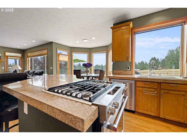 a kitchen with a stove a sink a window and dining table