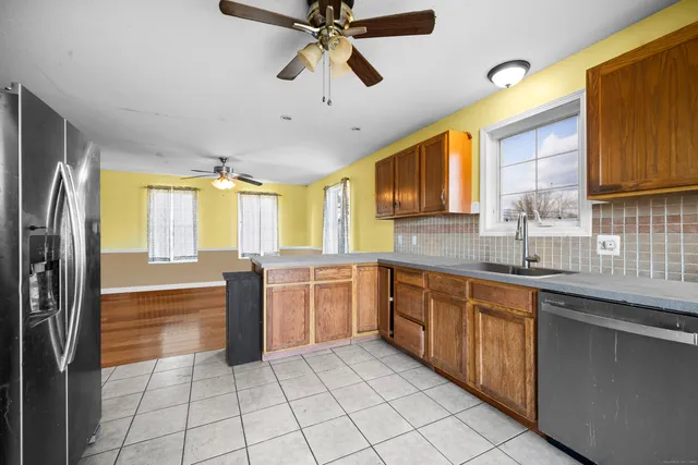 a large kitchen with kitchen island granite countertop a sink a counter top space and stainless steel appliances