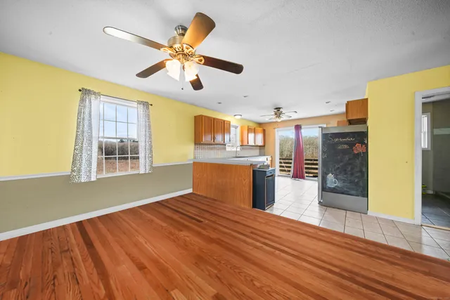 a view of a kitchen with wooden floor and a ceiling fan