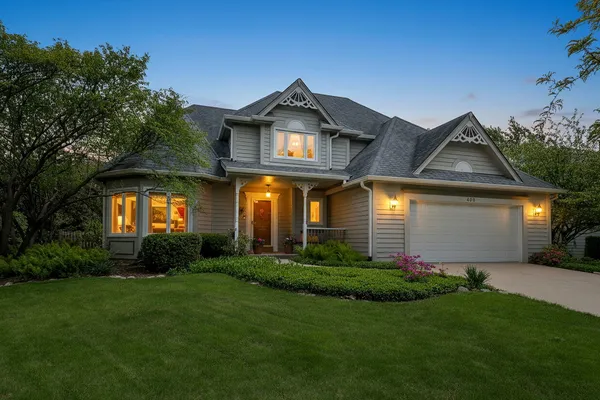 a front view of a house with a yard and trees