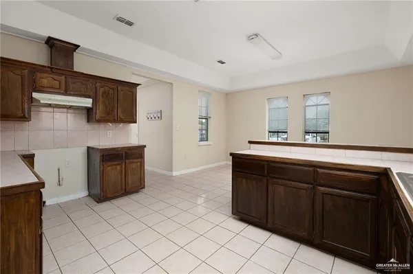a kitchen with a sink and a stove top oven with wooden floor