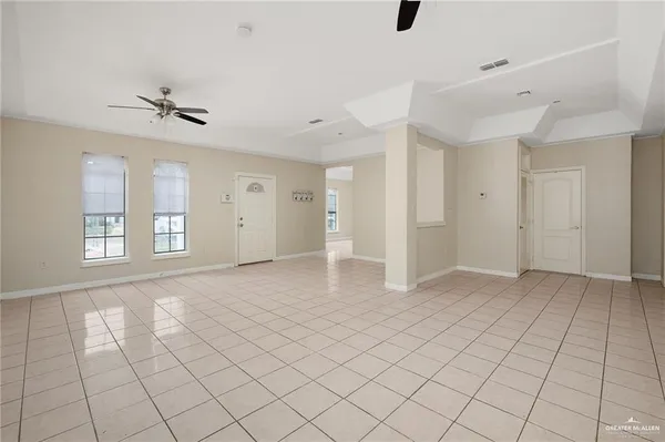 an empty room with windows and ceiling fan