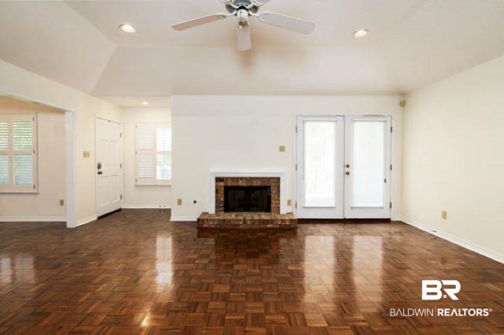12 Stonebridge Court Mobile, AL 36608 - Photo 8 of 38 Unfurnished living room featuring healthy amount of natural light, vaulted ceiling, ceiling fan, a brick fireplace, and recessed lighting