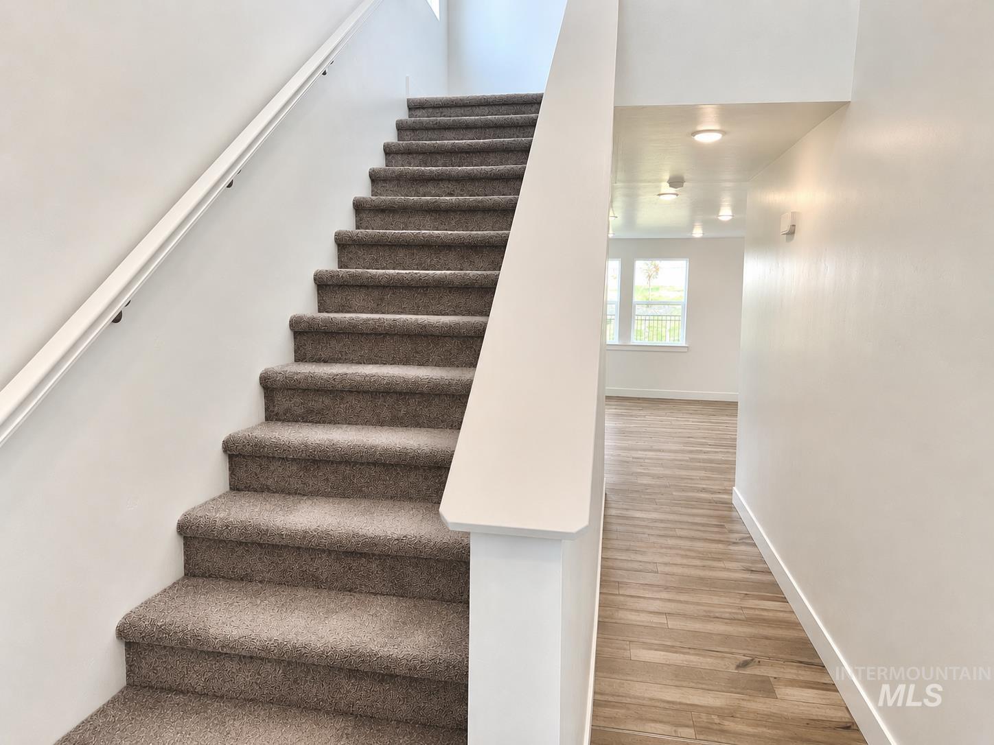 8098 West Fern Street Eagle, ID 83616 - Photo 8 of 22 Carpeted staircase with white handrail and white baluster