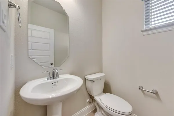 a bathroom with a sink a toilet and mirror