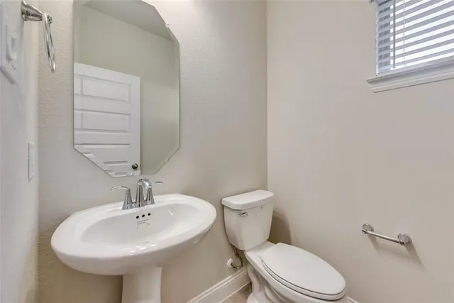 a bathroom with a sink a toilet and mirror