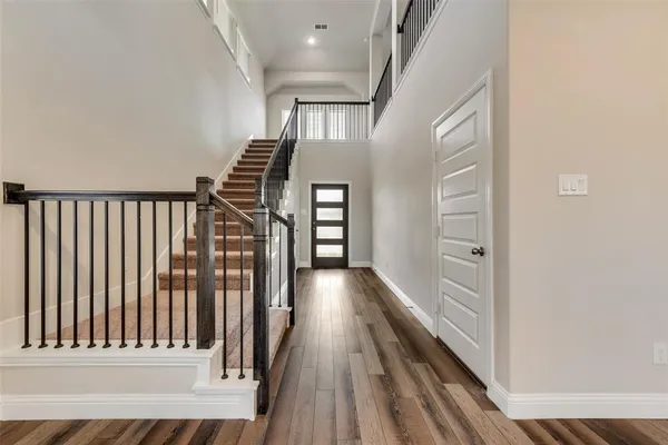 a view of a hallway with wooden floor and staircase