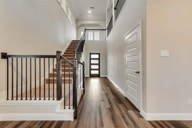 a view of a hallway with wooden floor and staircase