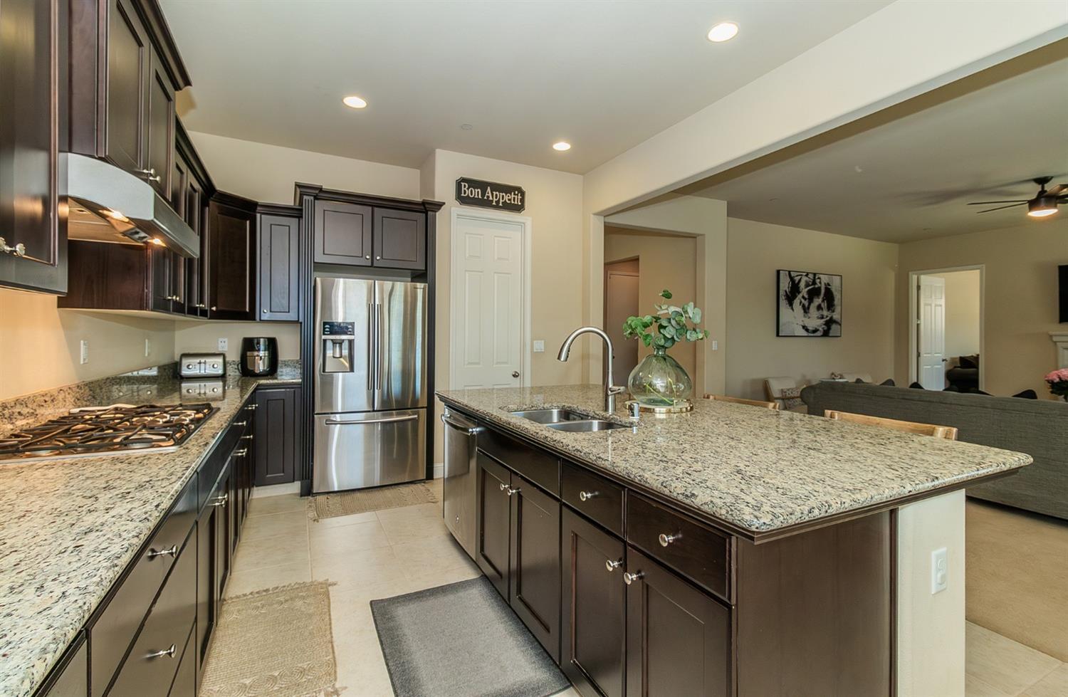 2610 Sample Avenue Clovis, CA 93611 - Photo 11 of 36 a kitchen with stainless steel appliances granite countertop a sink stove and refrigerator