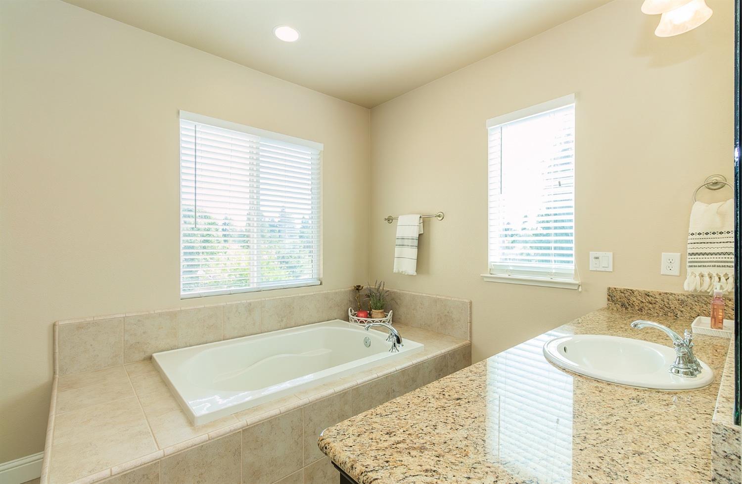 2610 Sample Avenue Clovis, CA 93611 - Photo 24 of 36 a bath tub sitting in a bathroom next to a window