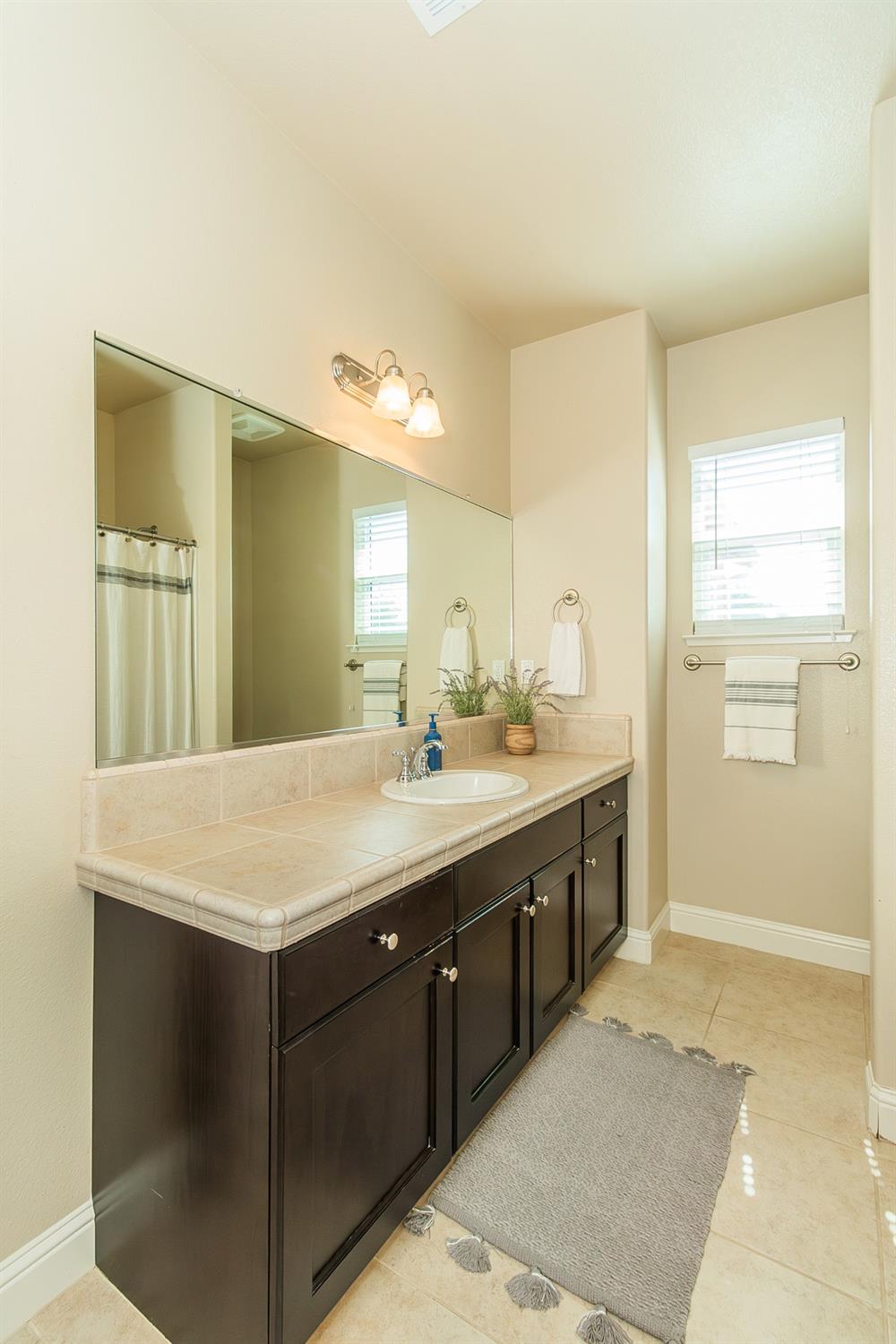 2610 Sample Avenue Clovis, CA 93611 - Photo 30 of 36 a bathroom with a sink a mirror and a shower