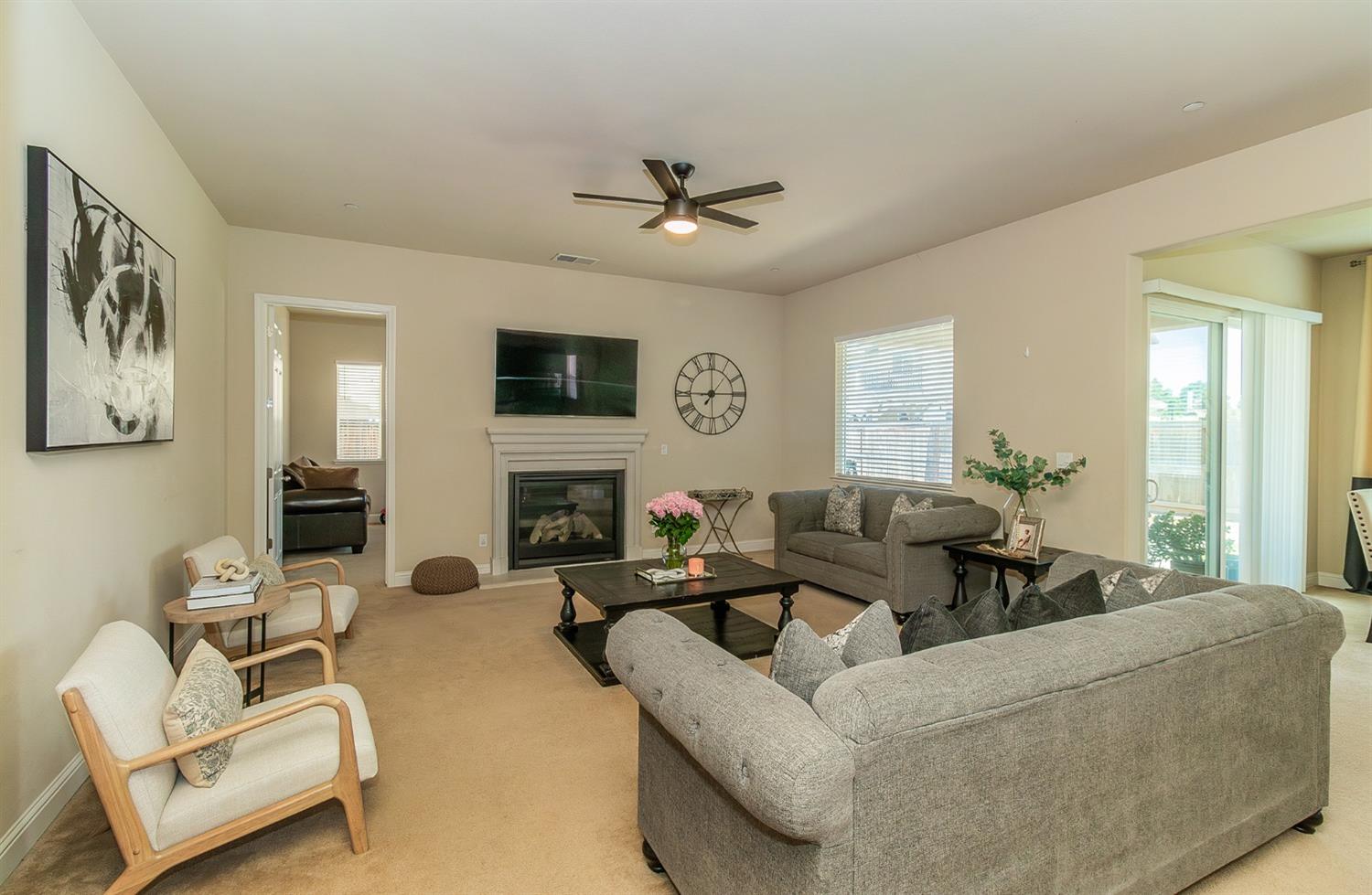 2610 Sample Avenue Clovis, CA 93611 - Photo 6 of 36 a living room with furniture a fireplace and a flat screen tv