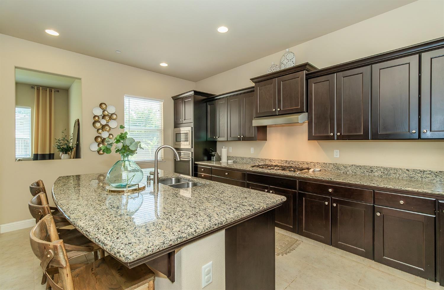 2610 Sample Avenue Clovis, CA 93611 - Photo 10 of 36 a kitchen with granite countertop kitchen island stainless steel appliances a sink stove and cabinets