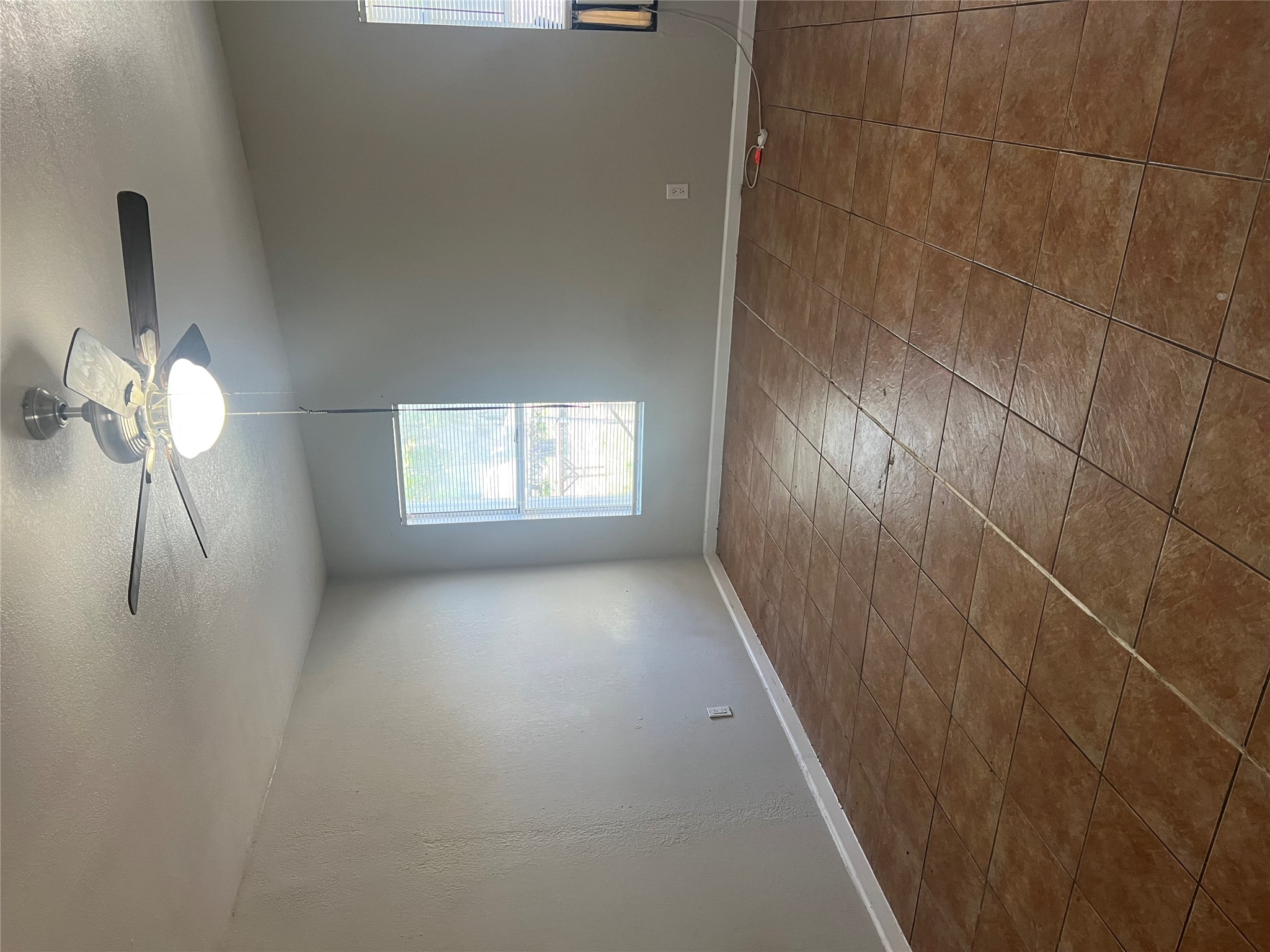6405 Torres Street Austin, TX 78741 - Photo 10 of 14 Well-lit room with durable tile flooring and a ceiling fan for year-round comfort.