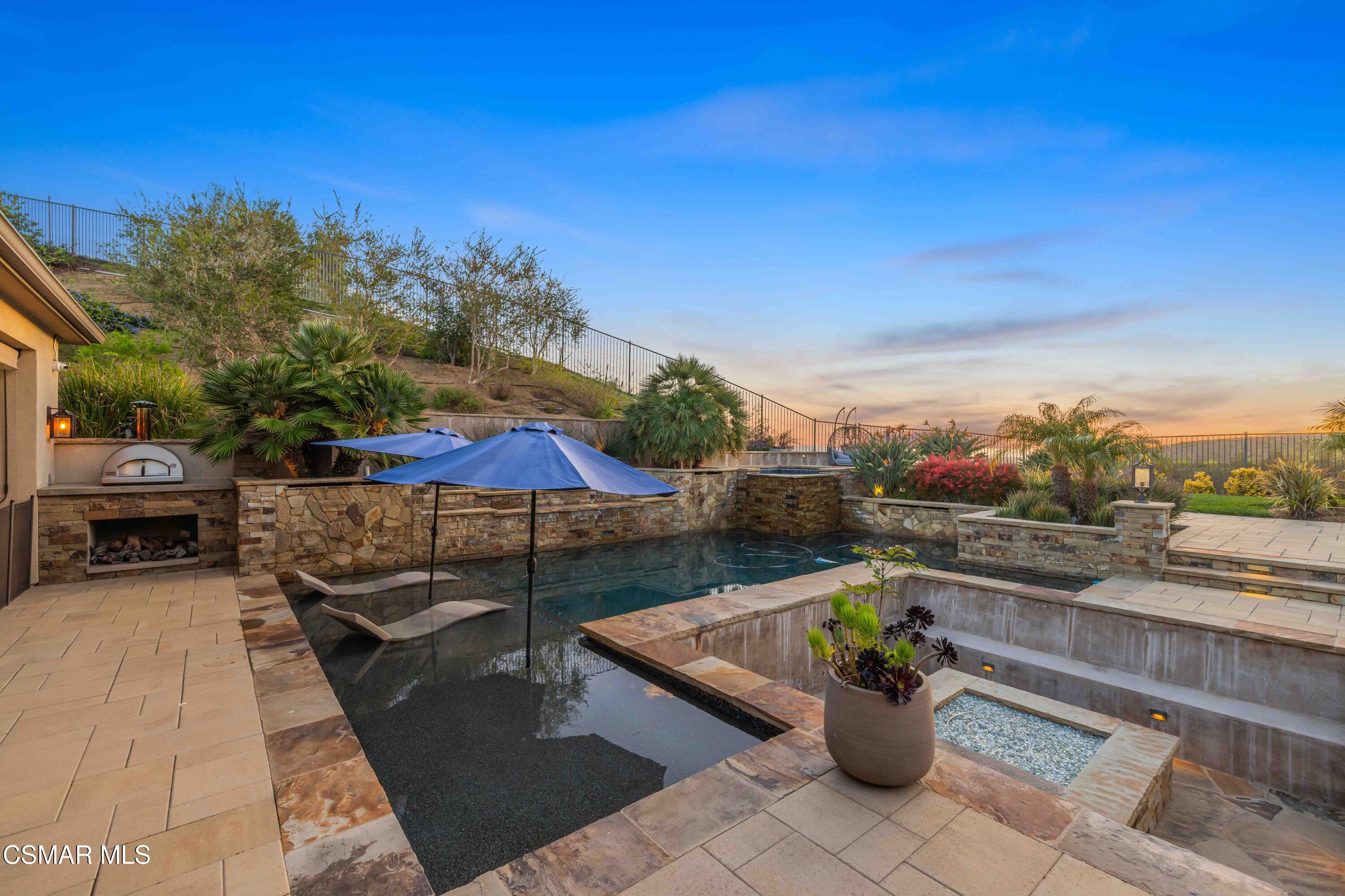 6508 High Country Place Moorpark, CA 93021 - Photo 3 of 95 a view of a patio with couches and a table and chairs under an umbrella