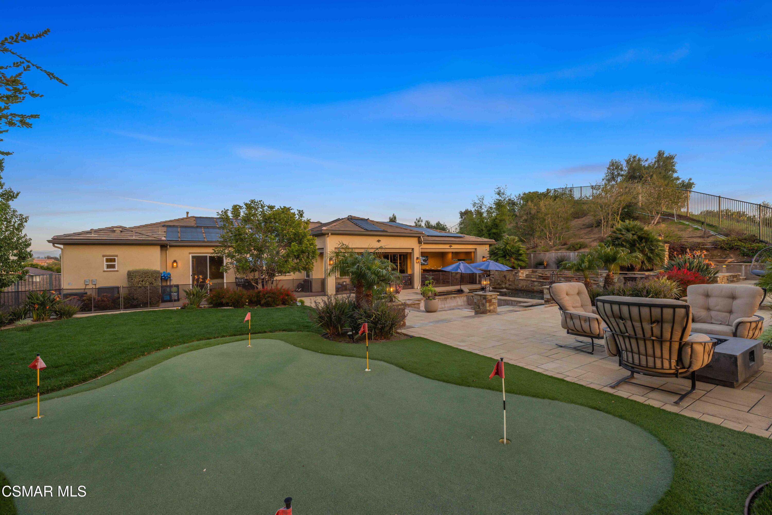 6508 High Country Place Moorpark, CA 93021 - Photo 78 of 95 a view of a patio with couches chairs under an umbrella next to a yard