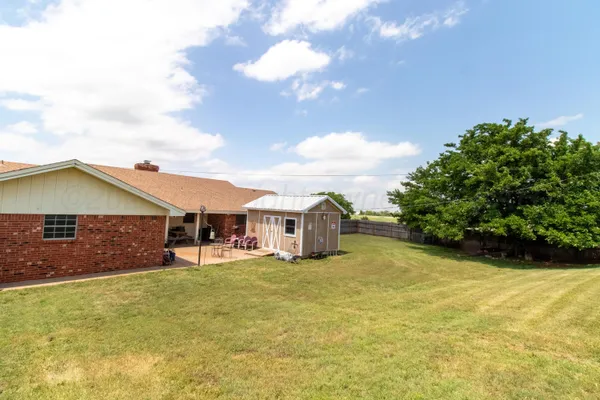 a view of a house with pool and a yard