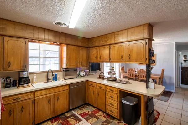 a kitchen with a sink a window and cabinets